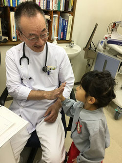 お子様を診察する院長